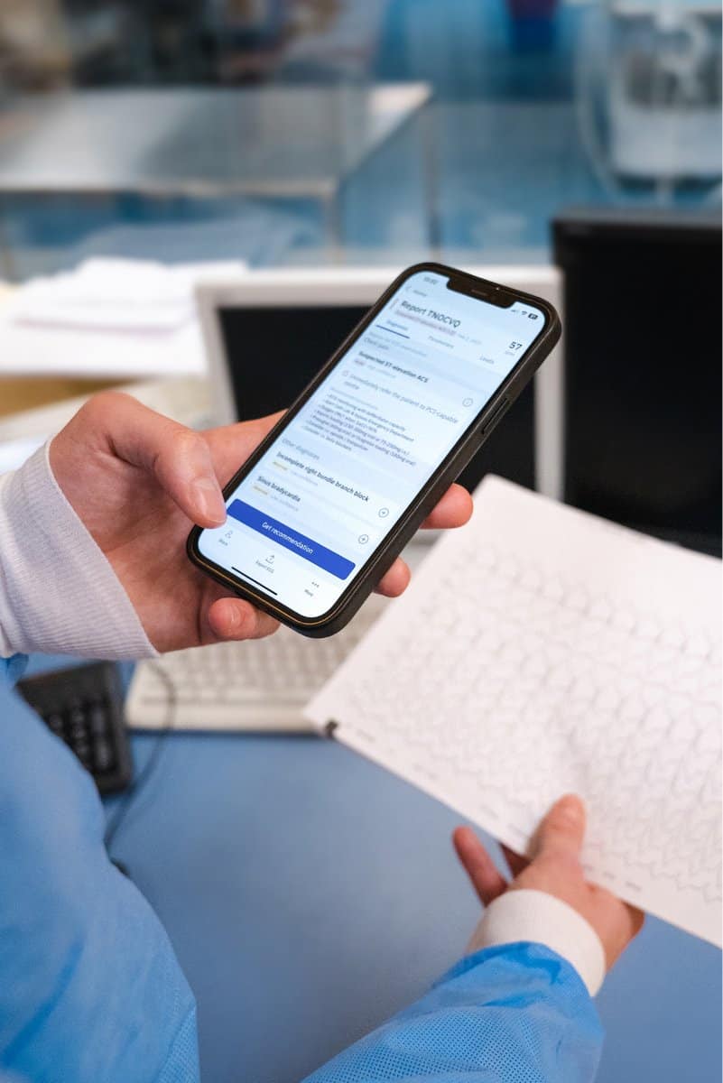 An image of a doctor interpreting a paper ECG with the PMcardio app