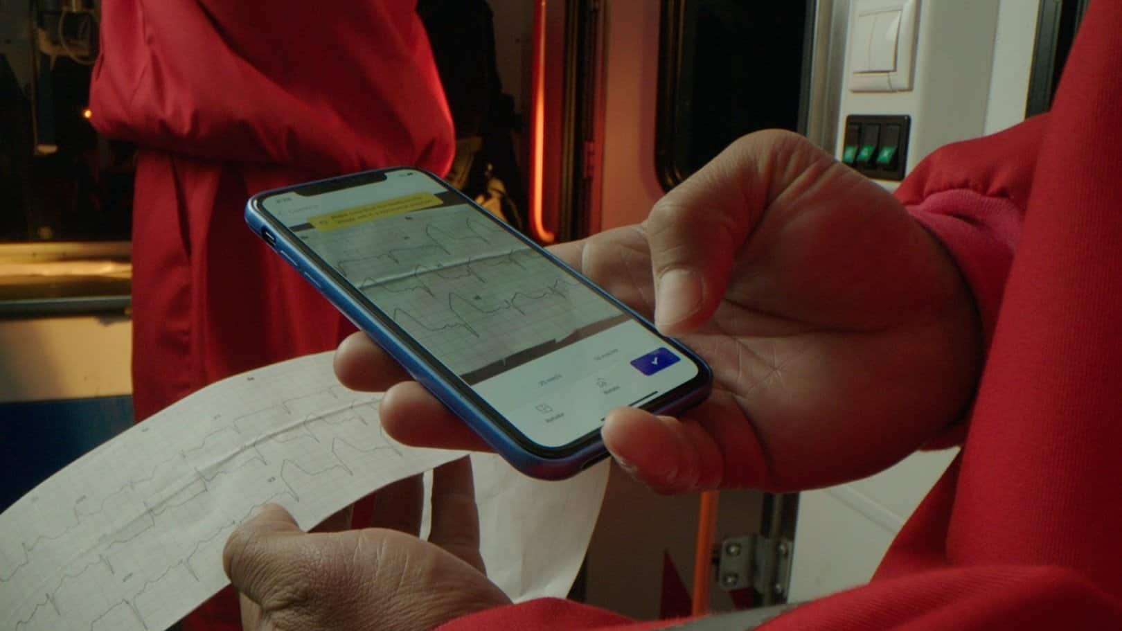 An image of an emergency medical professional scanning an ECG with their phone via the PMcardio app